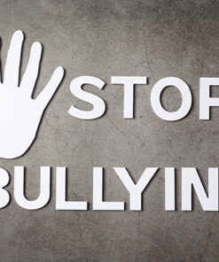 word "stop bullying" with hand sign on dark background